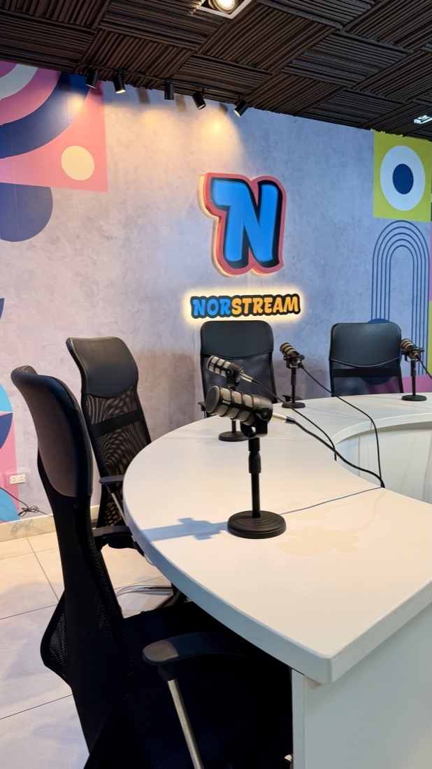 Cartel luminoso de Norstream TV junto a un micrófono de estudio